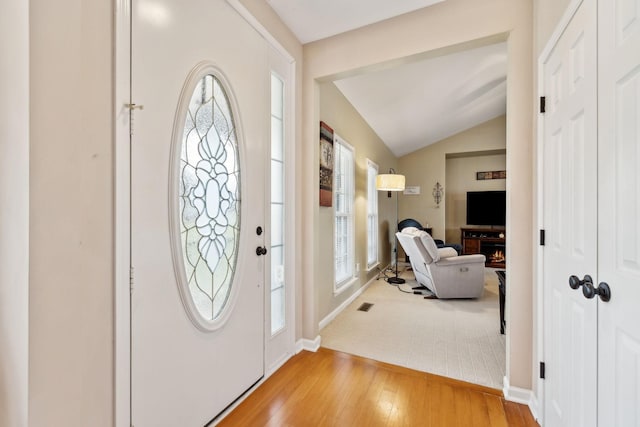 foyer featuring vaulted ceiling and wood-type flooring