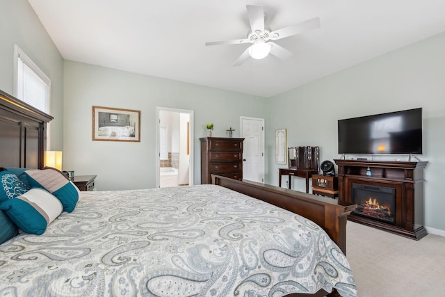 bedroom featuring ensuite bath, light colored carpet, and ceiling fan