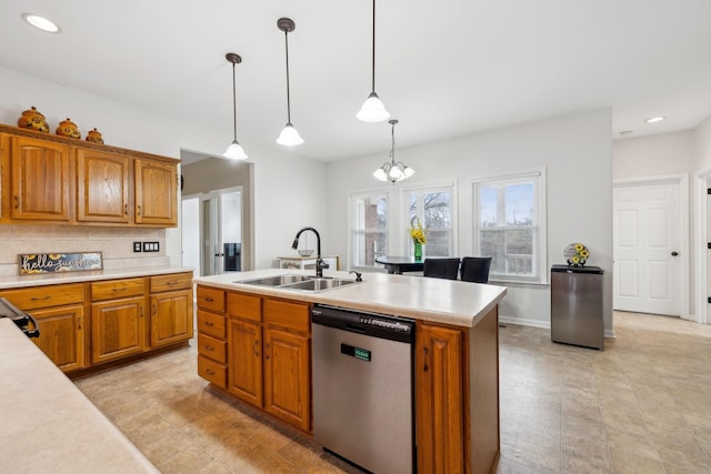 kitchen with decorative light fixtures, tasteful backsplash, dishwasher, sink, and a center island with sink