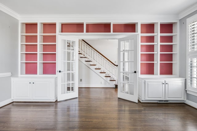 interior space featuring french doors, ornamental molding, dark wood-type flooring, and built in shelves