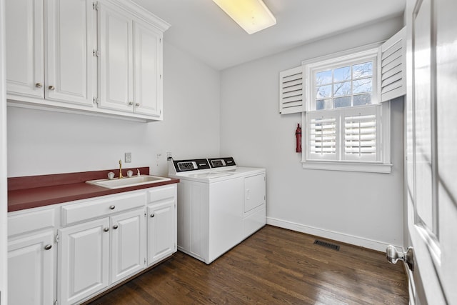 laundry room featuring dark hardwood / wood-style flooring, sink, cabinets, and washing machine and clothes dryer