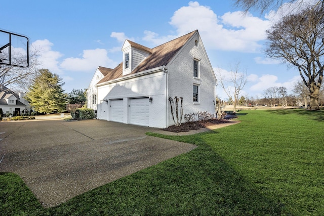 view of side of home featuring a garage and a lawn