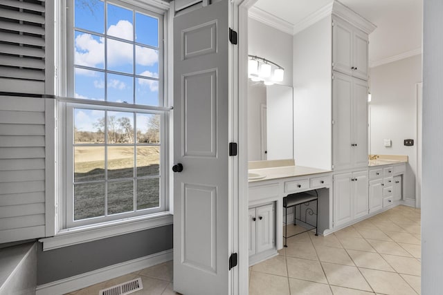 bathroom with crown molding, tile patterned floors, and vanity