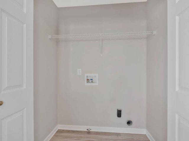 laundry room with light wood-type flooring, hookup for a gas dryer, hookup for a washing machine, and electric dryer hookup