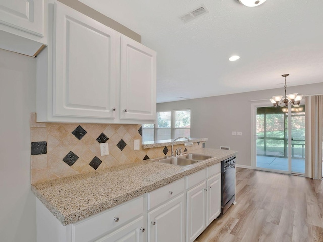 kitchen with decorative light fixtures, white cabinetry, black dishwasher, sink, and light stone counters