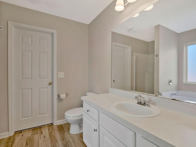 full bathroom with independent shower and bath, vanity, hardwood / wood-style floors, and toilet