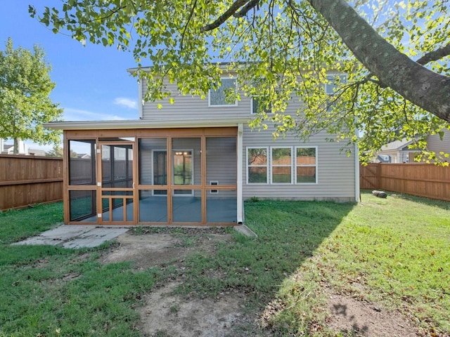 rear view of house with a yard and a sunroom