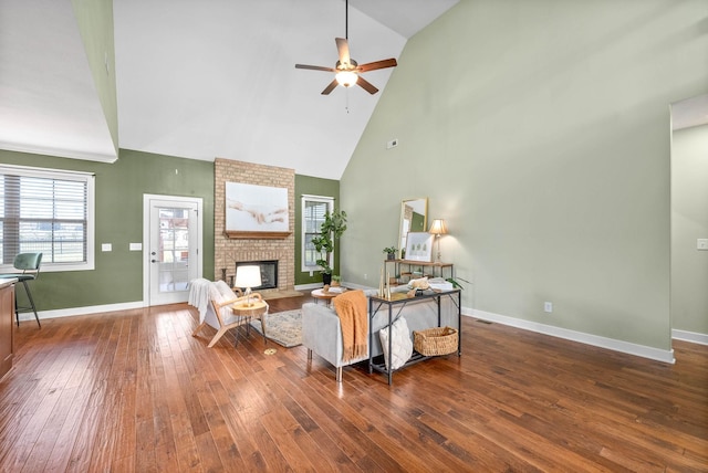 living room featuring a brick fireplace, high vaulted ceiling, dark hardwood / wood-style floors, and ceiling fan