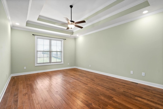 unfurnished room featuring hardwood / wood-style floors, crown molding, a raised ceiling, and ceiling fan