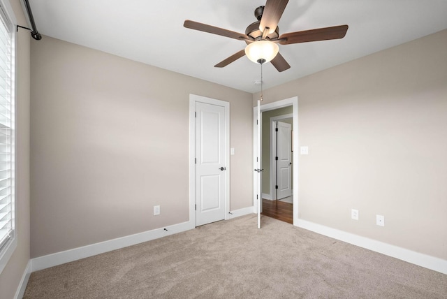 unfurnished bedroom featuring light carpet and ceiling fan