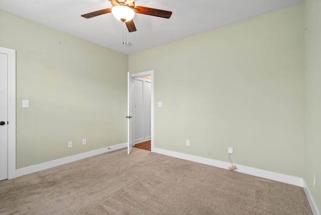 empty room featuring light colored carpet and ceiling fan