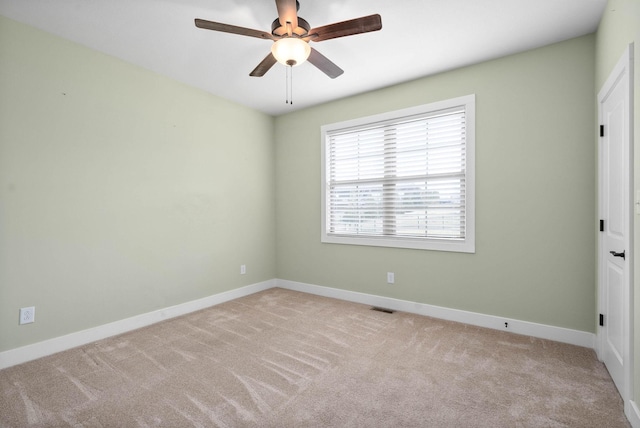 empty room featuring light colored carpet and ceiling fan