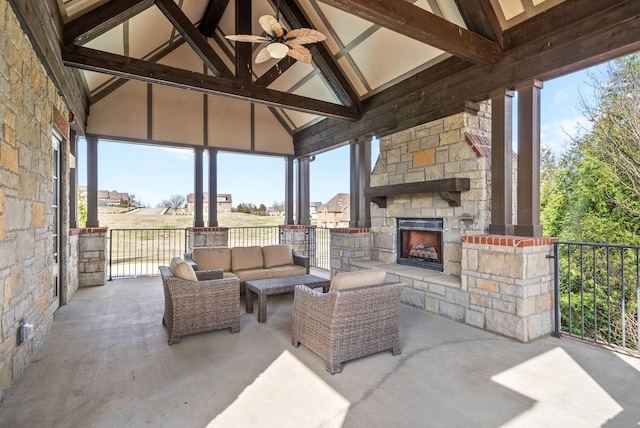 view of patio with an outdoor living space with a fireplace and ceiling fan