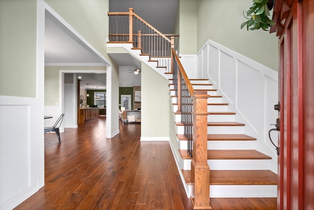 stairs with hardwood / wood-style flooring, ceiling fan, and crown molding