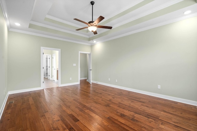 empty room with crown molding, ceiling fan, wood-type flooring, and a tray ceiling