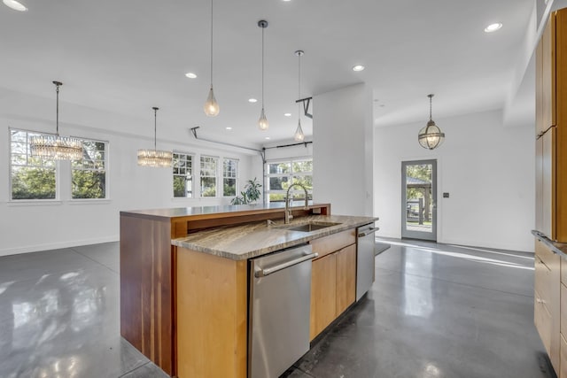 kitchen featuring a kitchen island with sink, sink, decorative light fixtures, and stainless steel dishwasher