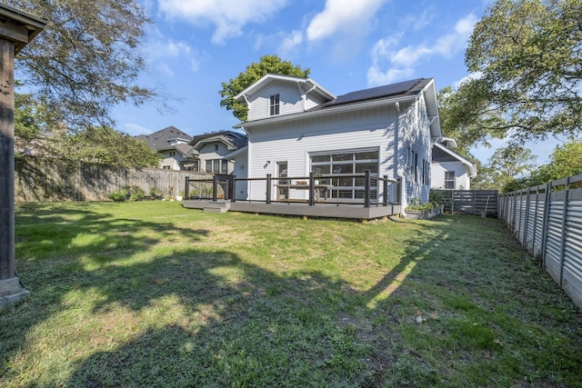 back of property featuring a wooden deck and a yard