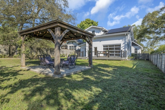 back of house featuring a gazebo, a patio area, a lawn, and solar panels