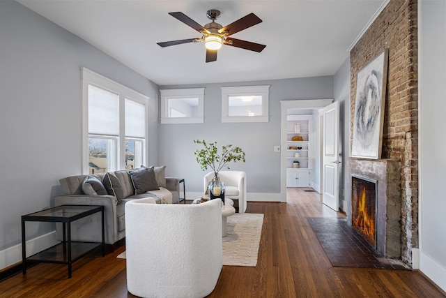 living room with ceiling fan, a fireplace, and dark hardwood / wood-style floors