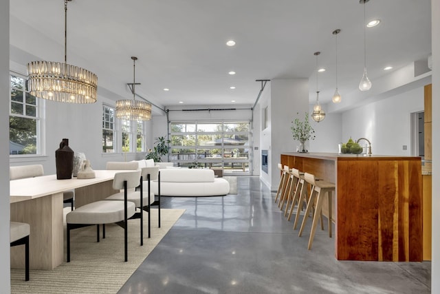 dining space with an inviting chandelier, concrete flooring, and sink