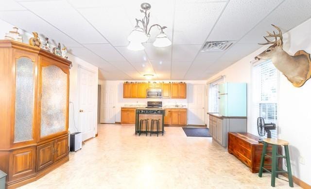 kitchen featuring decorative light fixtures and a paneled ceiling