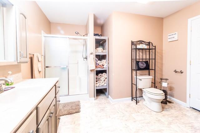 bathroom featuring vanity, toilet, and an enclosed shower