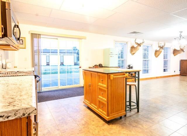 kitchen with hanging light fixtures, a wealth of natural light, and a kitchen breakfast bar