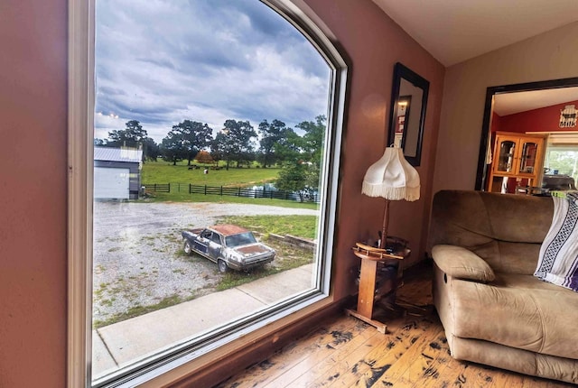 interior space featuring a water view, vaulted ceiling, and light hardwood / wood-style flooring