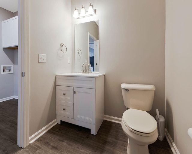 bathroom with wood-type flooring, vanity, and toilet