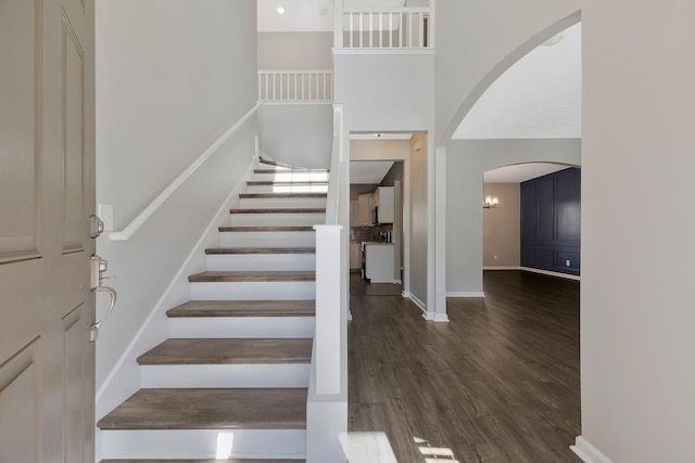 stairs with a high ceiling and hardwood / wood-style floors