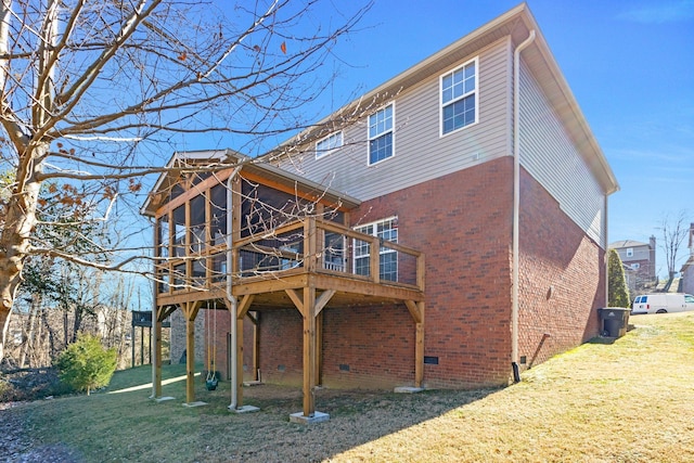 rear view of house with a deck and a lawn