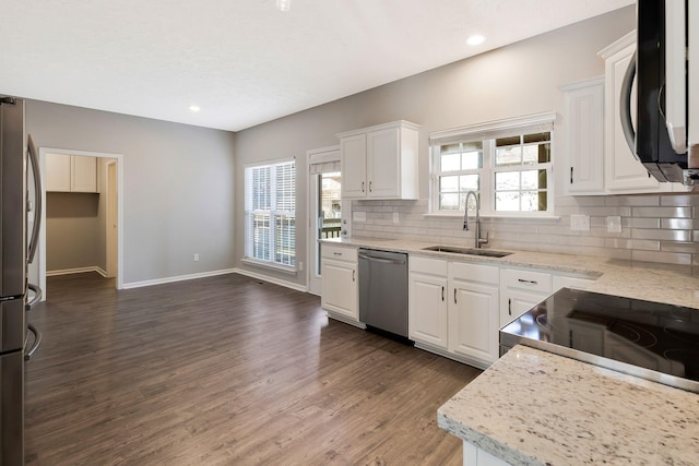 kitchen with sink, white cabinetry, tasteful backsplash, appliances with stainless steel finishes, and dark hardwood / wood-style floors