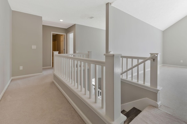 corridor featuring light carpet and lofted ceiling