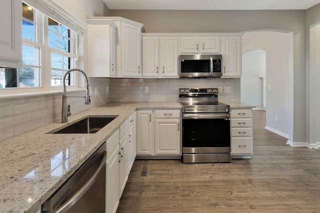 kitchen with sink, dark hardwood / wood-style floors, white cabinets, and appliances with stainless steel finishes