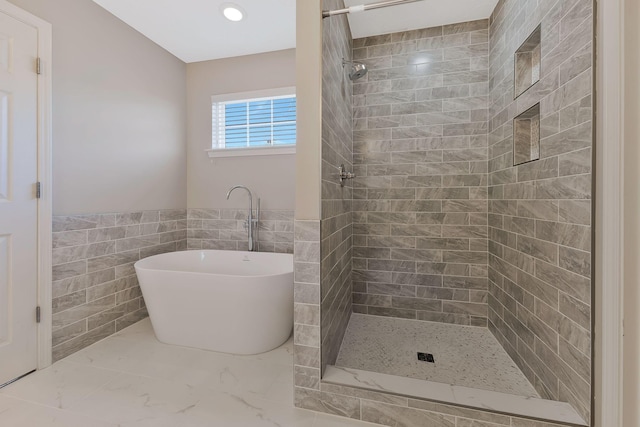 bathroom with separate shower and tub and tile walls