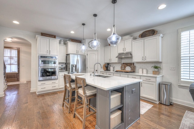 kitchen featuring white cabinetry, sink, decorative light fixtures, and appliances with stainless steel finishes