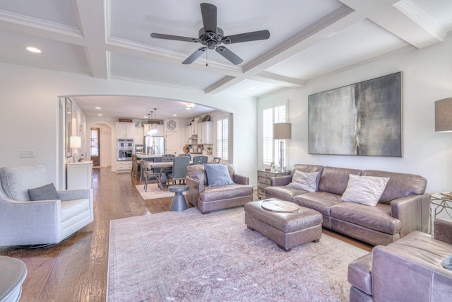 living room featuring beamed ceiling, wood-type flooring, coffered ceiling, and ceiling fan