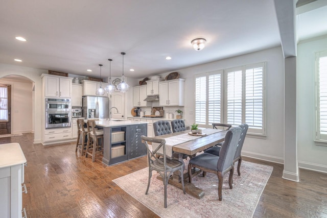 dining area featuring dark wood-type flooring and sink