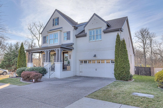 view of front of house with a garage, covered porch, and a front lawn