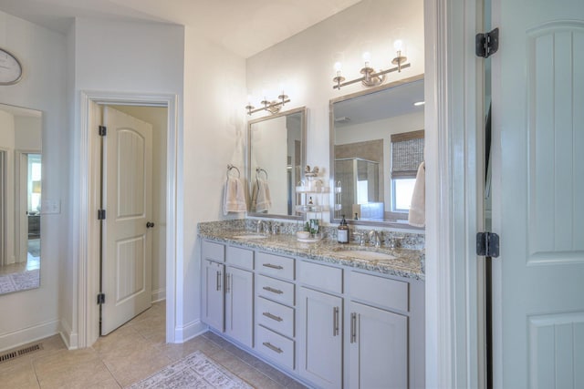 bathroom with tile patterned flooring, vanity, and walk in shower