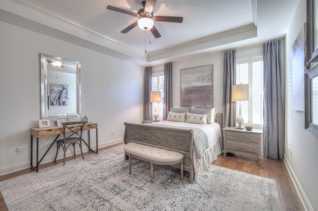 bedroom featuring crown molding, ceiling fan, a tray ceiling, and hardwood / wood-style floors