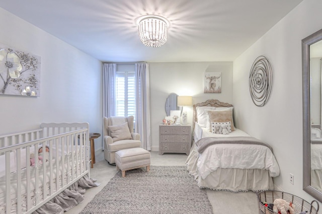 carpeted bedroom with a notable chandelier