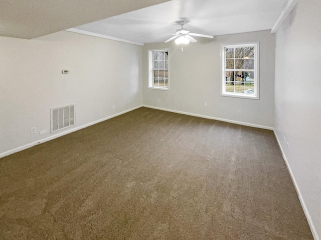 empty room featuring ceiling fan and dark carpet