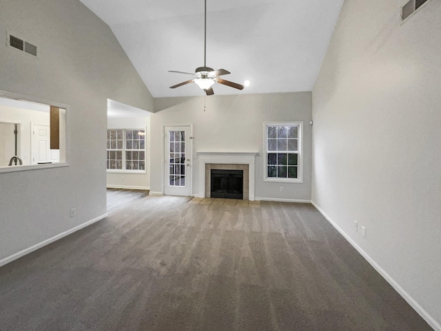 unfurnished living room with a tile fireplace, carpet, high vaulted ceiling, and ceiling fan