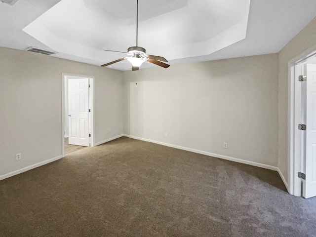 unfurnished bedroom featuring carpet floors, a raised ceiling, and ceiling fan