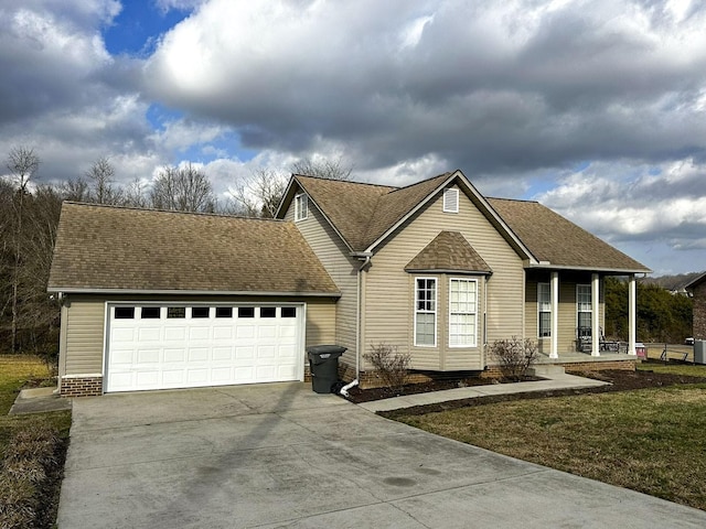 view of front of house featuring a garage, covered porch, and a front lawn