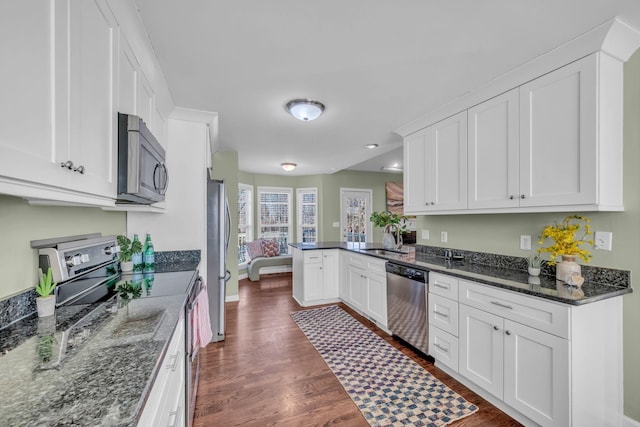 kitchen featuring stainless steel appliances, white cabinetry, sink, and kitchen peninsula