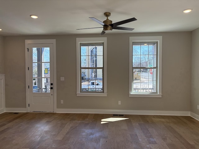 foyer entrance with visible vents, plenty of natural light, baseboards, and wood finished floors