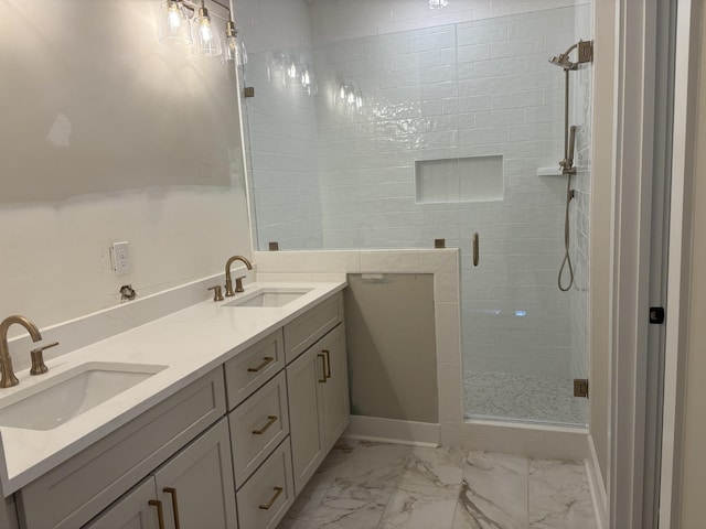 bathroom with marble finish floor, a sink, a shower stall, and double vanity