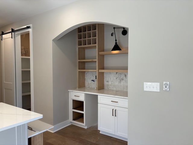 bar featuring a barn door and dark wood-style flooring